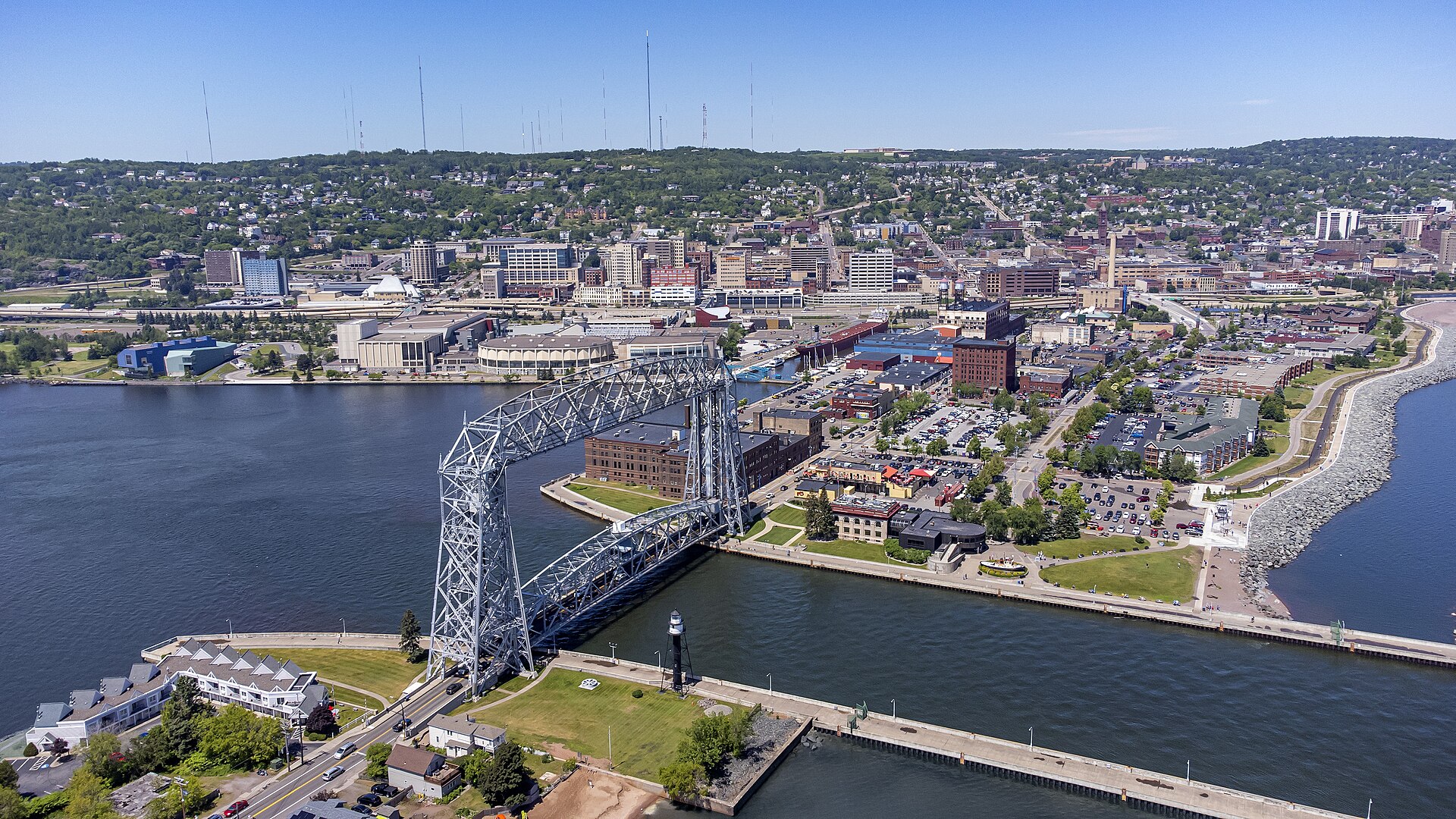 Duluth's Aerial Lift Bridge spanning the ship canal, with Canal Park and downtown climbing the green hillside behind.