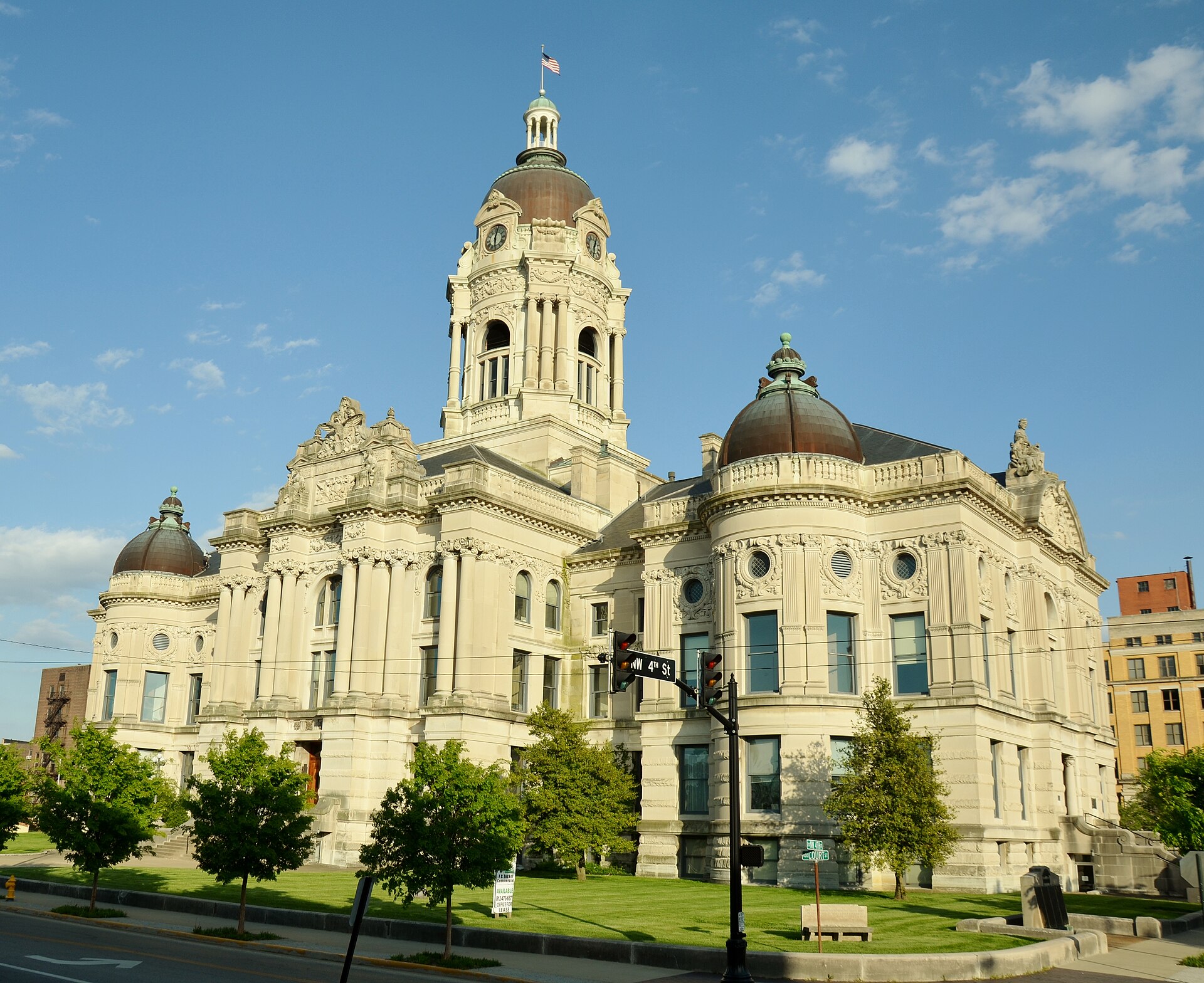 The ornate Old Vanderburgh County Courthouse in downtown Evansville, with its domed clock tower, under a blue sky.