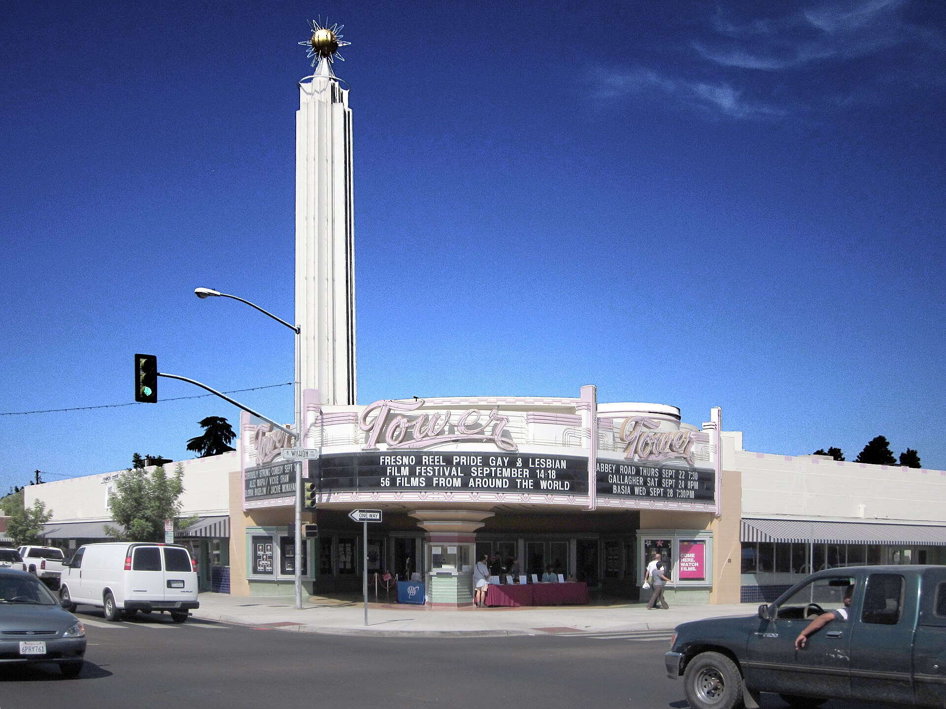 The Art Deco Tower Theatre's white spire and pastel "Tower" marquee in Fresno's Tower District under a deep blue sky.