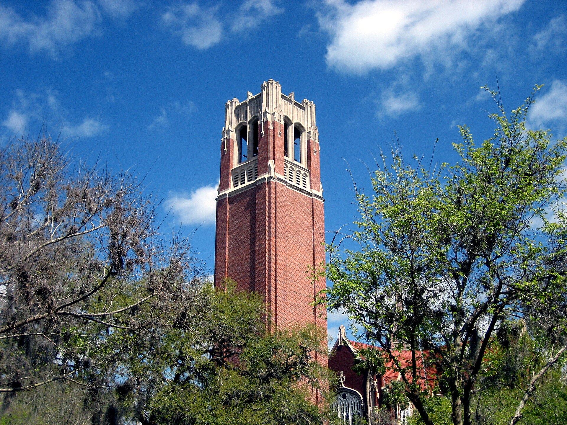 The red-brick Century Tower on the University of Florida campus in Gainesville against a bright blue sky.