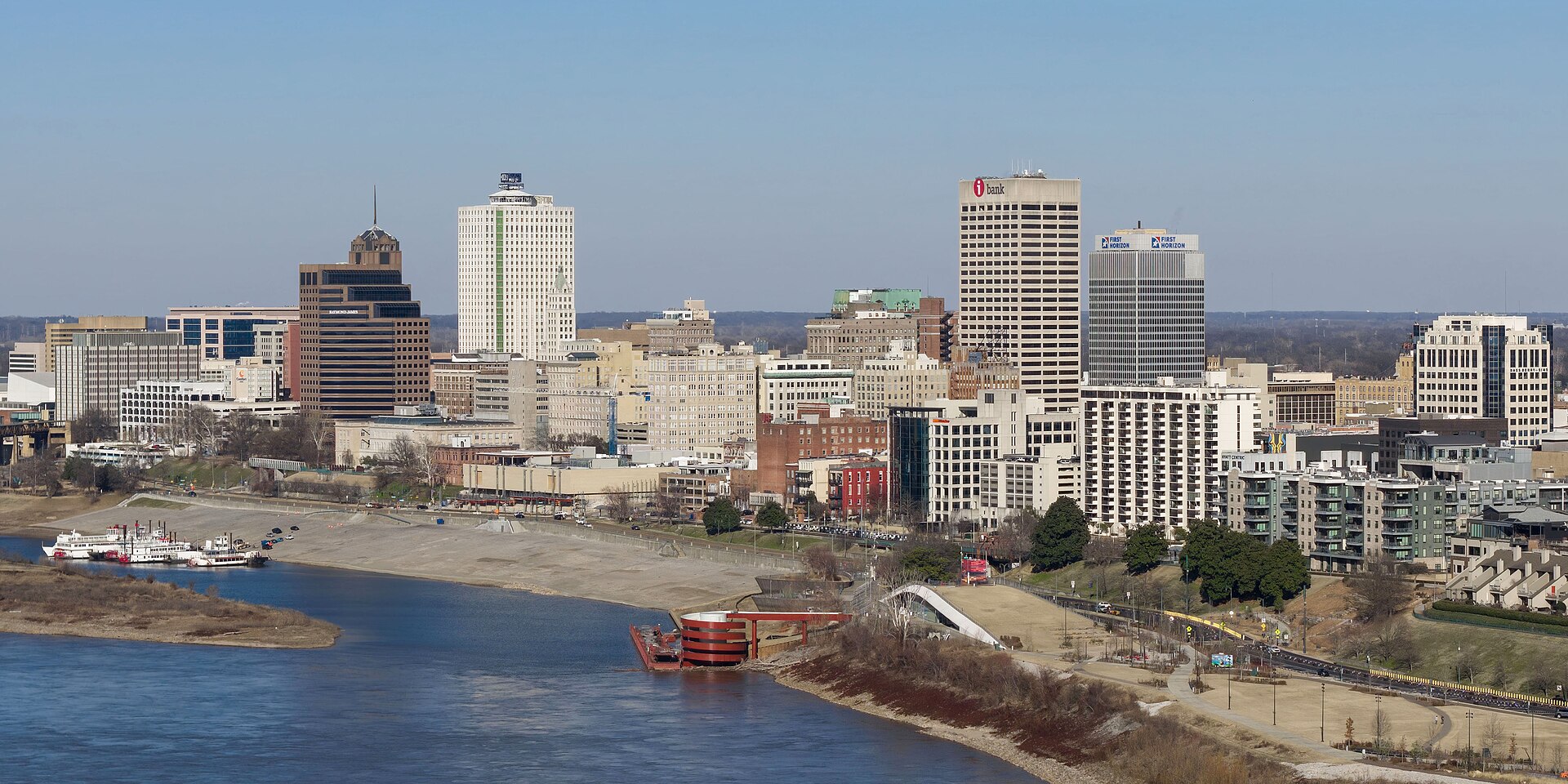 Downtown Memphis's skyline above the Mississippi River and its sandy riverbank on a clear day.
