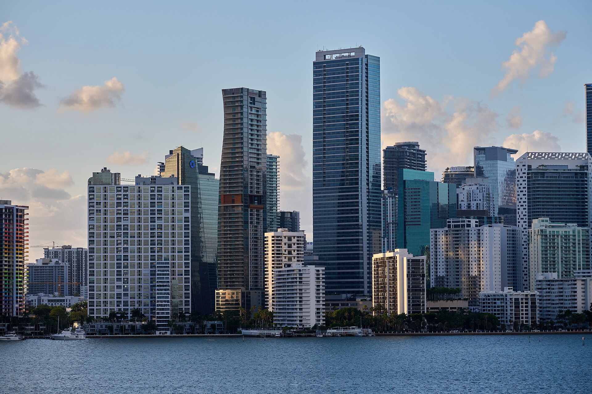 The towers of Miami's Brickell district rising above the blue water of Biscayne Bay in late-afternoon sun.