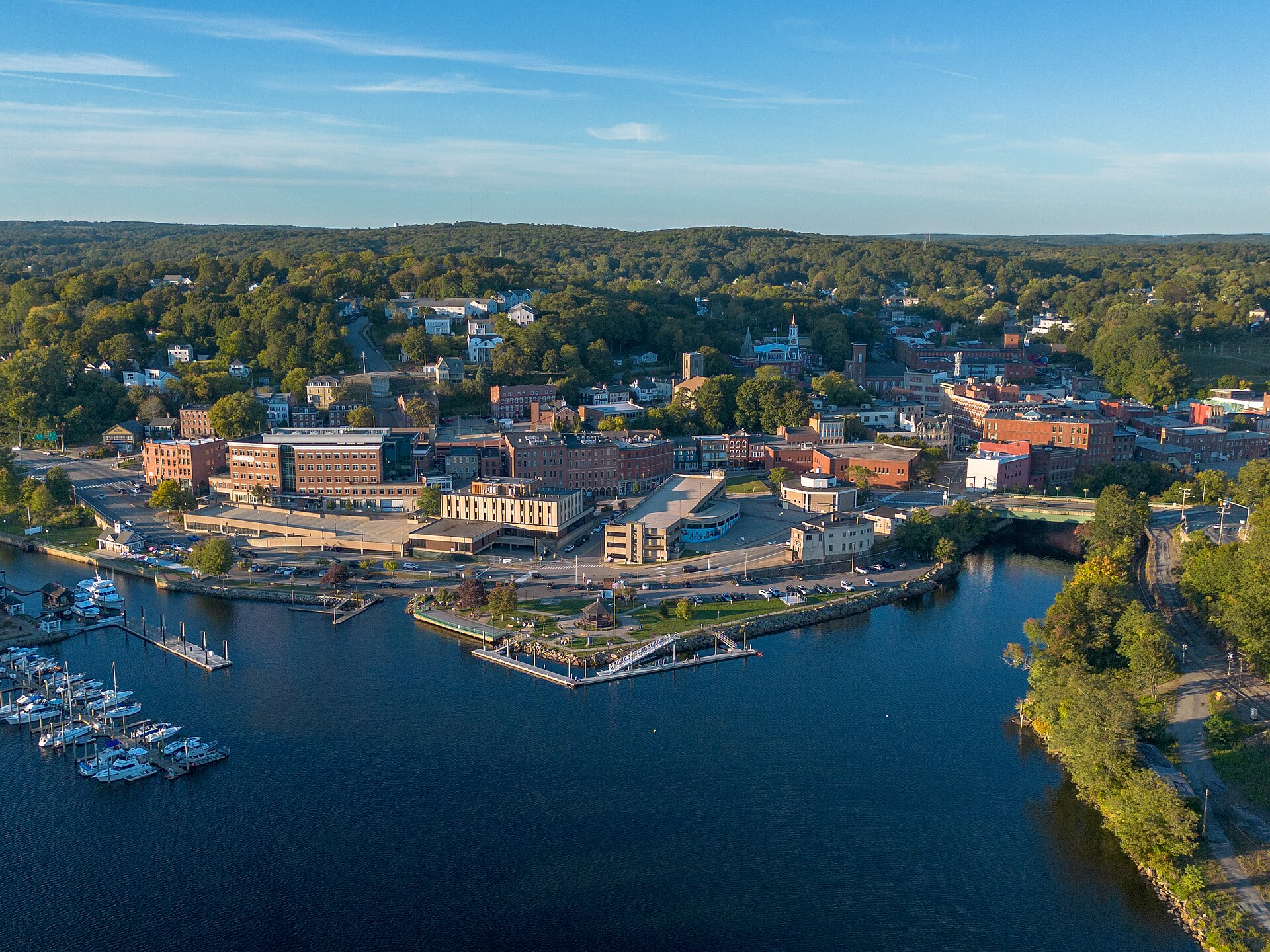 Norwich's harbor, marina and brick downtown at the head of the Thames River, seen from above in warm late-day light.