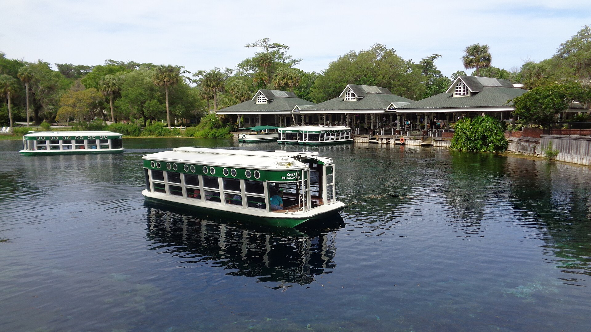 Glass-bottom boats on the clear blue headspring at Silver Springs near Ocala, with palm trees and the old boathouse.