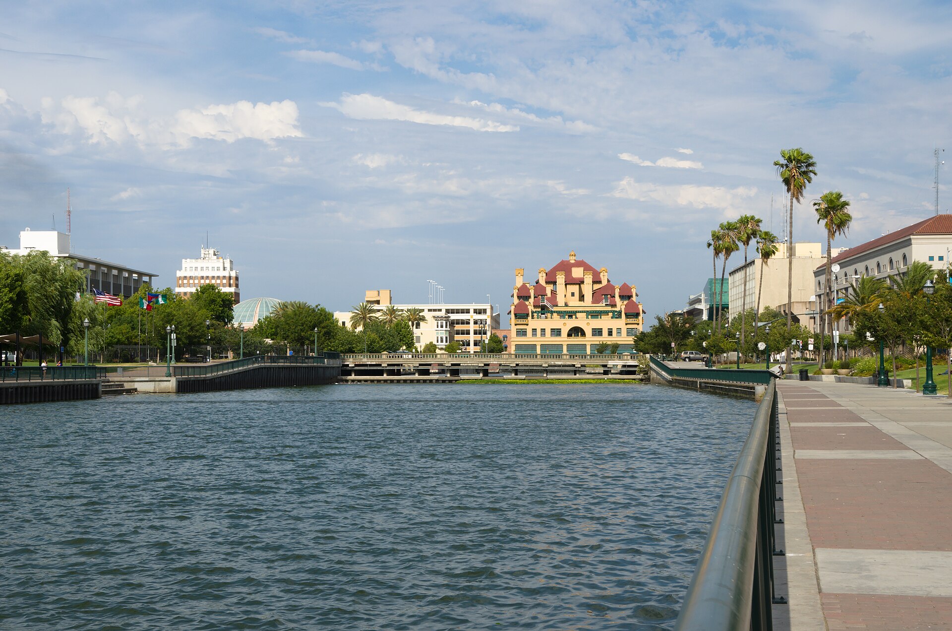 The Stockton Channel leads to the ornate Hotel Stockton, with palm trees and a waterside promenade in downtown Stockton.